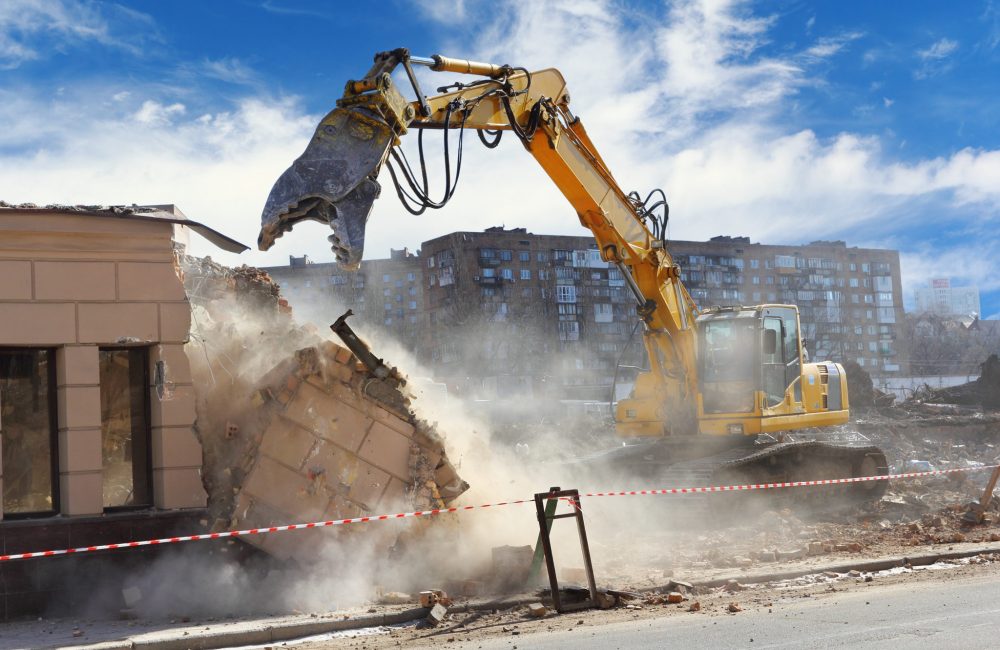 Bulldozer crushing the building at construction site