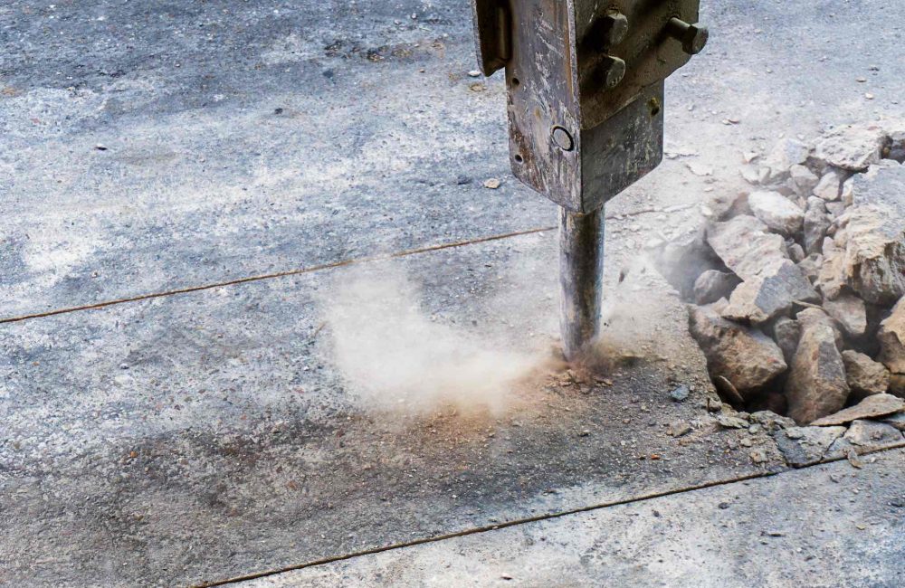 Excavator hydraulic  jack hammer is breaking concrete road prepare for water piping system work